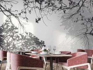 Le papier peint panoramique « RAMOS » nous place sous une branche, dans un jardin ou dans une forêt. Le dessin du décor mural se décline en noir et gris très clair. Le vent d’automne a fait son œuvre car quelques feuilles ont déjà disparu. Plusieurs plans habillent la tapisserie.