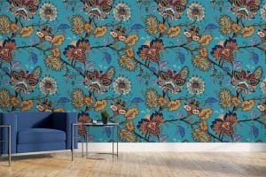 Le papier peint panoramique « Mandil » propose un fond de couleur ocre. Sur la tapisserie, des fleurs stylisées façon mandala s’additionnent dans des arabesques végétales. On dirait un tissu indien. Une variété de petits motifs compose les fleurs du décor mural : traits, gouttes, corolles, points… Les couleurs réveillent la teinte ocre (violet, bleu électrique, bleu turquoise, blanc, rouge, orange, bordeaux…).